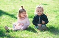 Cute boy and girl sit on grass on summer field. Baby child in green grass on spring lawn. Little kids walking in the Royalty Free Stock Photo