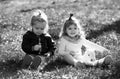 Cute boy and girl on summer field. Happy children playing sitting on green grass in spring park. Royalty Free Stock Photo