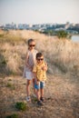 Cute boy and girl in sunglasses stand in field hugging