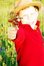 Cute boy give strawberries and smiling in a field Royalty Free Stock Photo