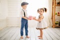 Cute boy gives a beautiful girl a gift. Little boy and girl in the room. Love concept. Royalty Free Stock Photo