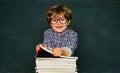 Cute boy with happy face expression near desk with school supplies. First school day. Schoolkid or preschooler learn