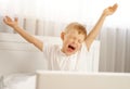 The cute boy wakes up with his arms outstretched and yawns. Royalty Free Stock Photo