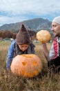 Cute boy in hat with father and Halloween Carved Pumpkin on the