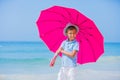 Boy with a pink umbrella on the sandy beach Royalty Free Stock Photo