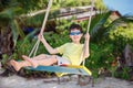 Cute boy having fun swinging at tropical island beach Royalty Free Stock Photo