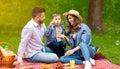 Cute boy with his parents having fun on picnic, blowing soap bubbles at park Royalty Free Stock Photo