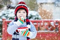 Cute boy holding big cup and hot chocolate drink and marshmallo Royalty Free Stock Photo