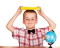 Cute boy holding book over his head, globe isolated. Royalty Free Stock Photo