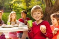 Cute boy holding cupcake with his friends sitting Royalty Free Stock Photo