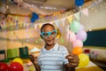 Cute boy holding sparkler and cupcake during birthday party Royalty Free Stock Photo