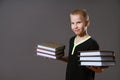 Cute boy holding stacks of books on gray background Royalty Free Stock Photo