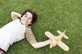 Cute Boy Holding Toy Airplane While Lying On Grass Royalty Free Stock Photo