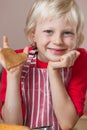 Cute boy holding up gingerbread love heart Royalty Free Stock Photo