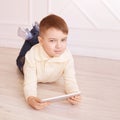 Cute boy. Computer tablet. play game, chat. Training. light interior Royalty Free Stock Photo