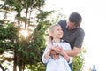 A cute boy hugs his dad\'s hands and looks at his father. The man bent over the child Royalty Free Stock Photo