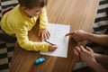 Cute boy kneeling on the floor and connecting dots on a piece of paper Royalty Free Stock Photo
