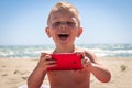 Cute boy laughing while playing with smart phone Royalty Free Stock Photo