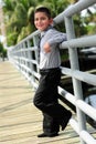 Cute Boy leanings against pole on bridge