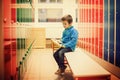 Cute boy in a locker room, sitting on a bench Royalty Free Stock Photo