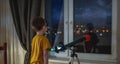 Cute boy is looking through a telescope at the night starry sky. Children`s passion for space exploration Royalty Free Stock Photo