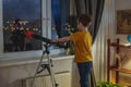 Cute boy is looking through a telescope at the night starry sky. Children`s passion for space exploration Royalty Free Stock Photo