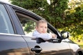 A cute boy looks out the car window and is sad. Open car window Royalty Free Stock Photo
