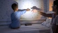 Cute boy with mother in pajamas playing with shadows on wall from the flashlight. Family having time together, parenting, happy Royalty Free Stock Photo