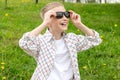 Cute boy with no tooth put on colorblind sunglasses and looks up Royalty Free Stock Photo