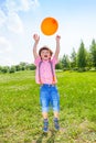 Cute boy with orange balloon in green field Royalty Free Stock Photo