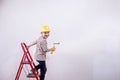 Cute boy with a paint roller. Happy kid helps parents to paint wall. New house for family