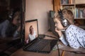 Cute boy talking with his grandmother within video chat on laptop, life in quarantine time Royalty Free Stock Photo