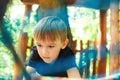 Cute boy passing cable tunnel. Outdoors playground, leisure for kids. Adventure rope park Royalty Free Stock Photo