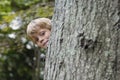 Cute Boy Peeking From Behind Tree