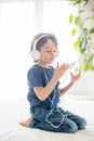 Cute boy with phone and head phones, listening music Royalty Free Stock Photo