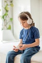 Cute boy with phone and head phones, listening music Royalty Free Stock Photo