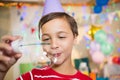 Cute boy playing with bubble wand during birthday party Royalty Free Stock Photo