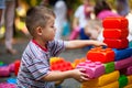 Cute boy playing with buiding toy colorful blocks. Kid with happy face playing with plastic bricks. Plastic Large Toy