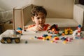 Cute boy is playing constructor at home. Kid playing block toys in home at nursery. Royalty Free Stock Photo