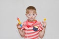 Cute boy playing doctor. Toy syringe, glasses and phonendoscope. Portrait Royalty Free Stock Photo