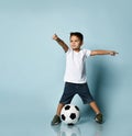 Cute boy playing football, happy child, young male teen goalkeeper enjoying sport game, holding ball Royalty Free Stock Photo