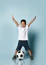 Cute boy playing football, happy child, young male teen goalkeeper enjoying sport game, holding ball Royalty Free Stock Photo