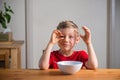 Cute boy playing with granola at breakfast. Genuine expressions.