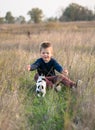 Cute boy playing with his dog in the meadow. Little puppy jack russel terrier on the walk with owner Royalty Free Stock Photo