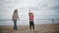 Cute boy playing kite with mother on beach. Caring parent teaching helping child Royalty Free Stock Photo