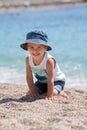 Cute boy, playing with pebbles on the beach Royalty Free Stock Photo