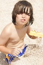 Cute boy, playing with pebbles on the beach in the morning Royalty Free Stock Photo