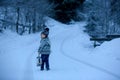 Cute boy playing with teddy bear in the snow, winter time. Little toddler playing with toys on snowy day Royalty Free Stock Photo