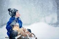 Cute boy playing with teddy bear in the snow, winter time. Little toddler playing with toys on snowy day Royalty Free Stock Photo