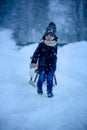 Cute boy playing with teddy bear in the snow, winter time. Little toddler playing with toys on snowy day Royalty Free Stock Photo